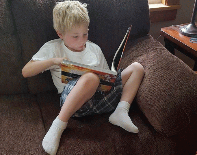 preschool-child-reading-at-home-to-get-trophy